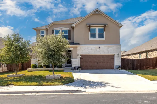 a front view of a house with a yard and garage
