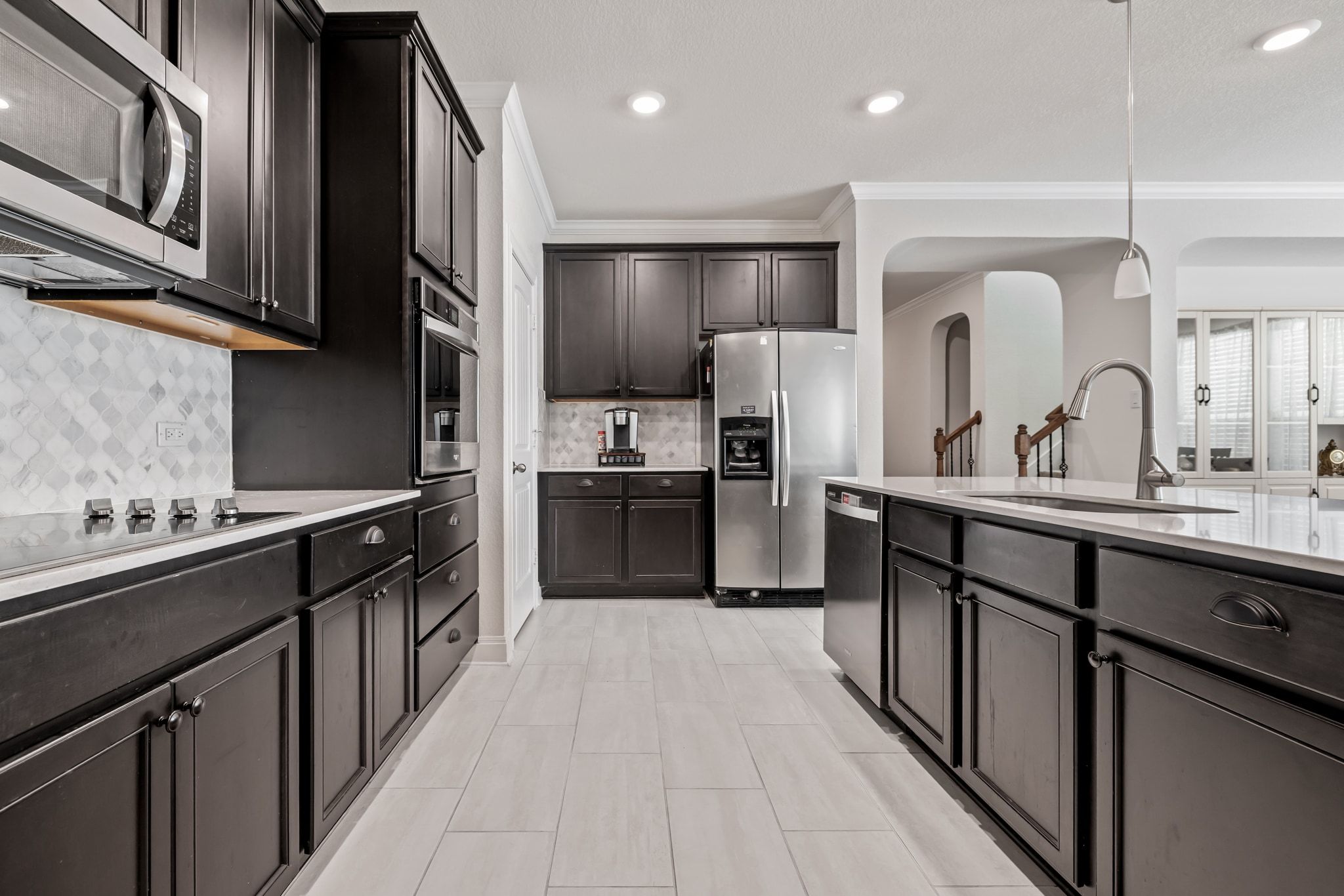 1022 Toltec Trail Georgetown, TX 78626 - Photo 13 of 37 Kitchen with tasteful backsplash, appliances with stainless steel finishes, decorative light fixtures, crown molding, and light stone countertops