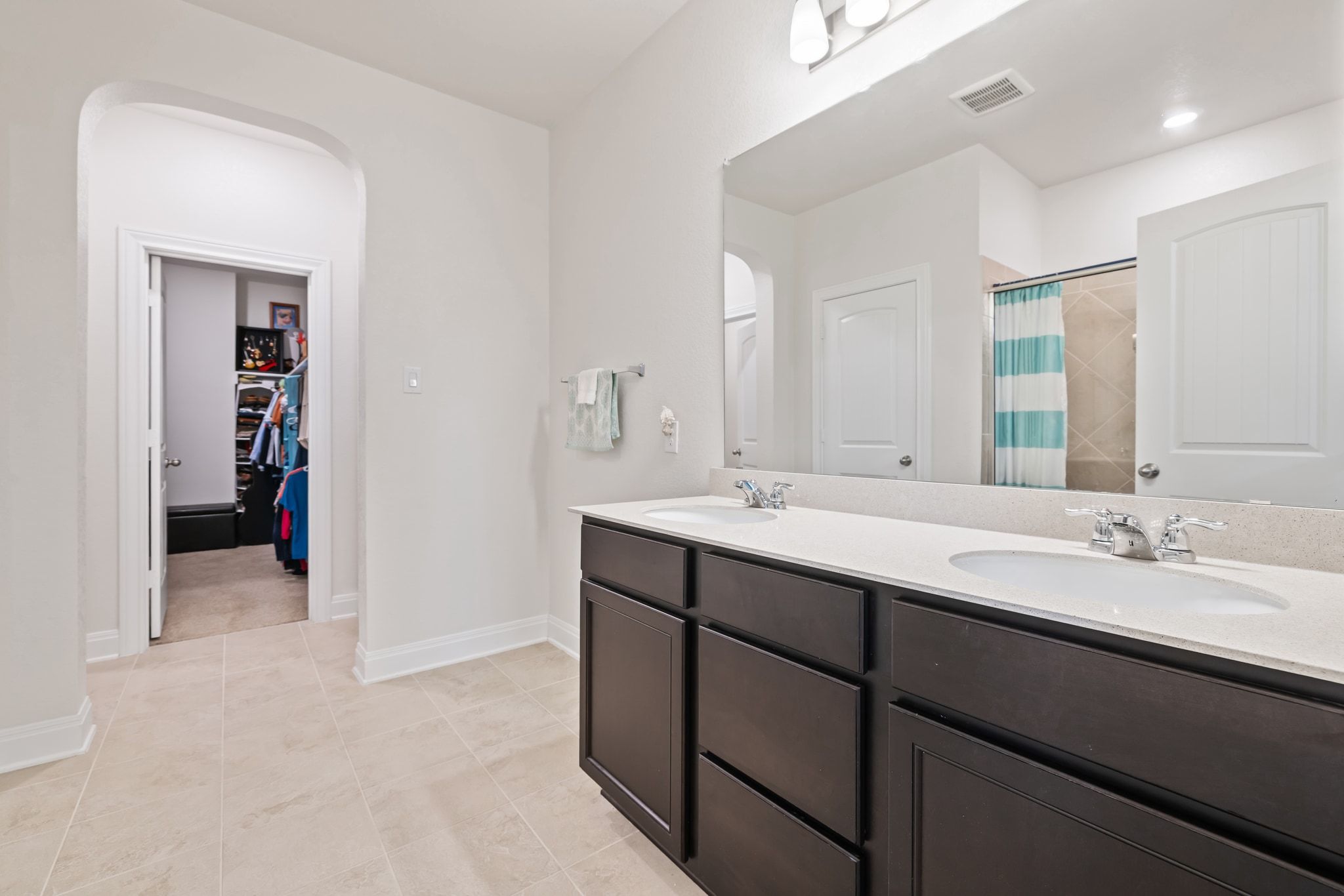 1022 Toltec Trail Georgetown, TX 78626 - Photo 19 of 37 Full bath featuring double vanity, a shower with shower curtain, a spacious closet, and light tile patterned floors