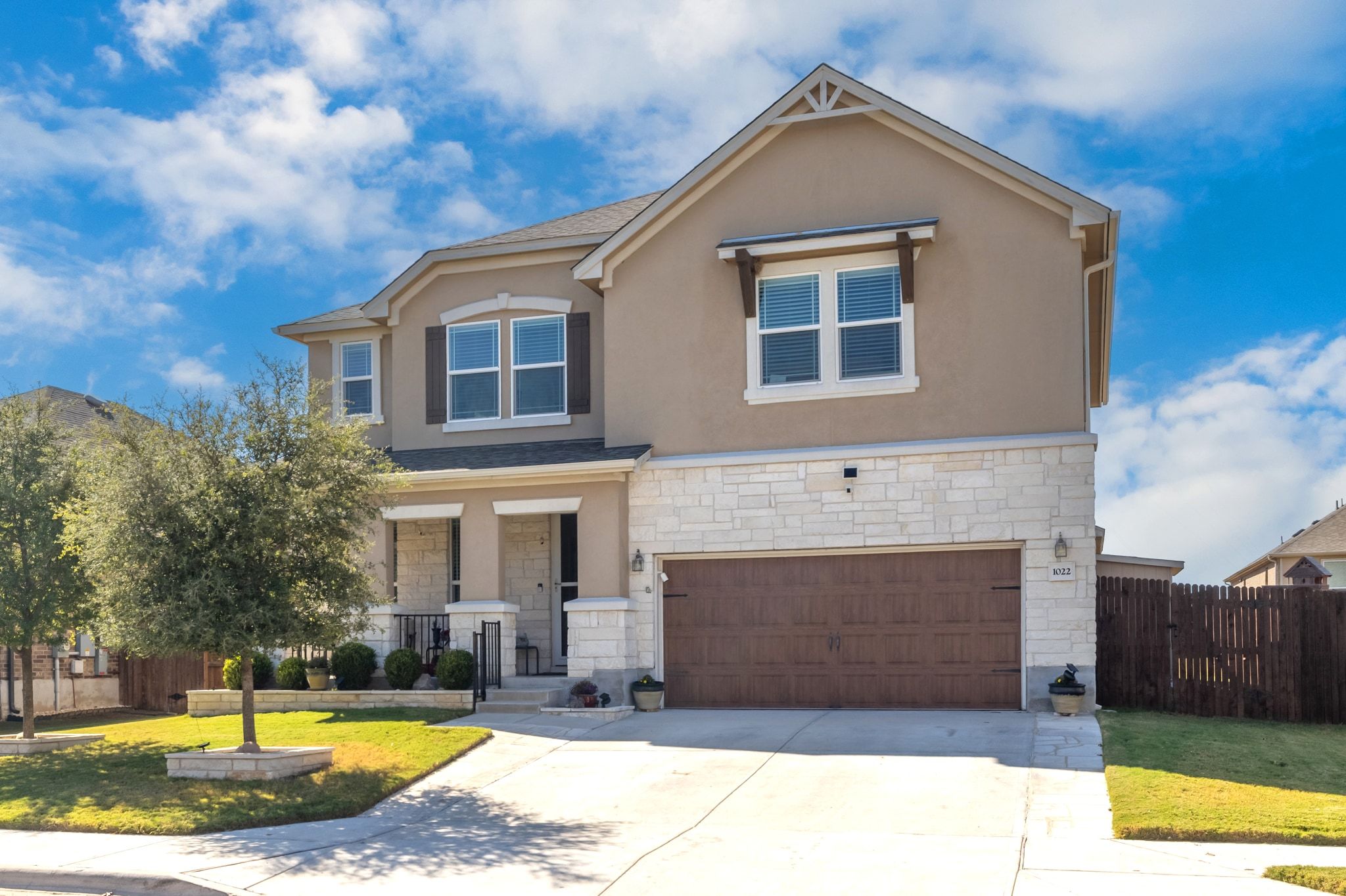 1022 Toltec Trail Georgetown, TX 78626 - Photo 2 of 37 View of front of home with stucco siding, concrete driveway, a porch, a garage, and stone siding
