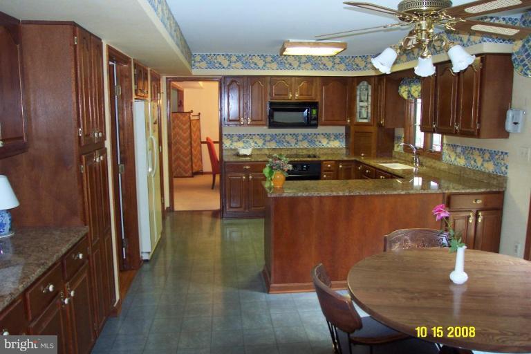 1015 Valewood Road Towson, MD 21286 - Photo 3 of 6 a kitchen with sink a refrigerator and chairs