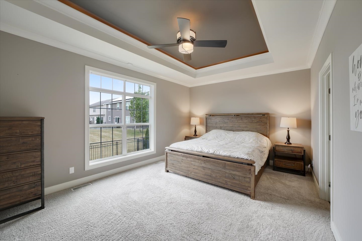 5104 Stonebridge Drive Champaign, IL 61822 - Photo 24 of 69 a spacious bedroom with a large bed and a chandelier fan