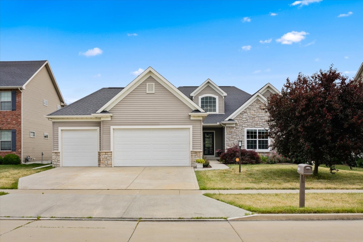 5104 Stonebridge Drive Champaign, IL 61822 - Photo 4 of 69 a view of a white house with a large windows and palm trees