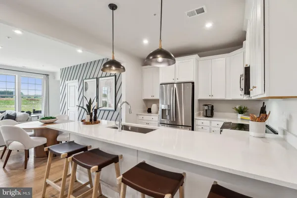 a kitchen with stainless steel appliances kitchen island granite countertop a sink a stove and a refrigerator