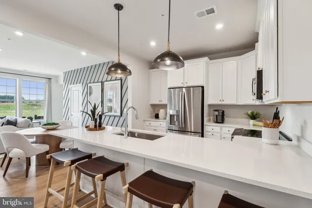 a kitchen with stainless steel appliances kitchen island granite countertop a sink a stove and a refrigerator