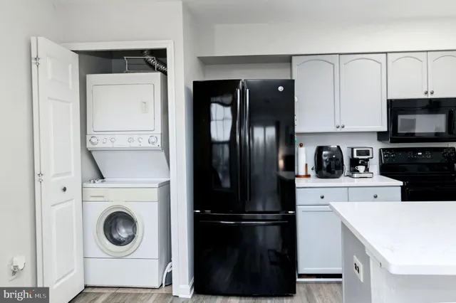 a kitchen with a refrigerator a stove top oven and cabinets