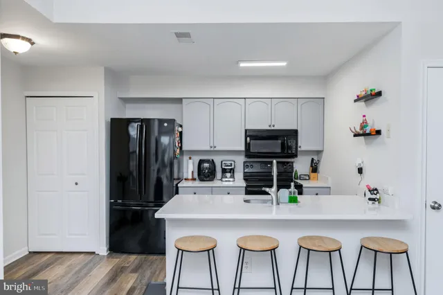 a kitchen with kitchen island a refrigerator and a stove top oven