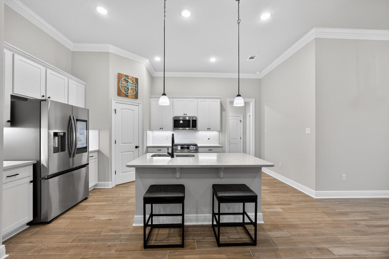 155 Lumen Loop Freeport, FL 32439 - Photo 12 of 48 a kitchen with kitchen island a sink stove and refrigerator
