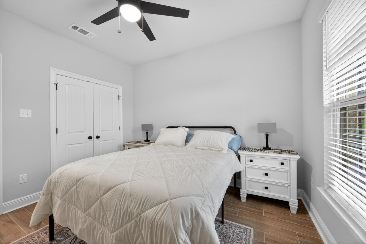 155 Lumen Loop Freeport, FL 32439 - Photo 24 of 46 a bedroom with a bed and wooden floor