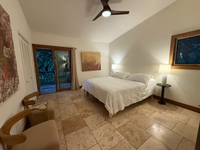 a bedroom with a bed and a potted plant on the dresser