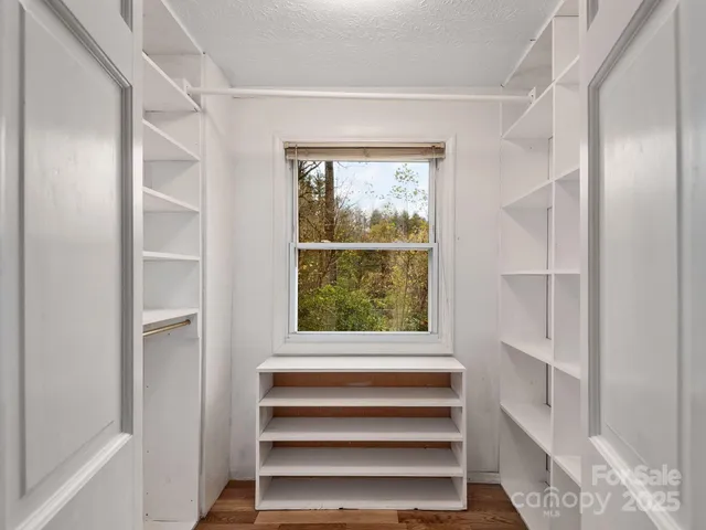 a view of an empty room with cabinet and a window