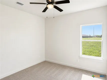 an empty room with a window and a ceiling fan