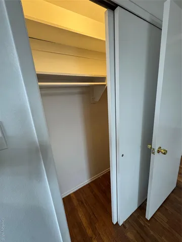 a view of walk in closet with wooden floor