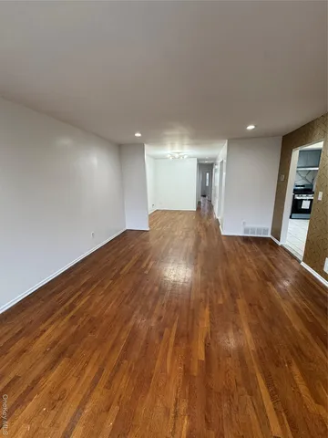 a big room with wooden floor and natural light