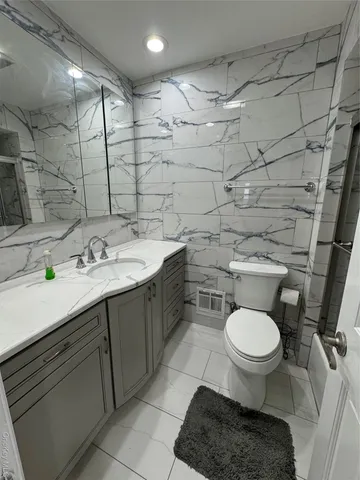 a bathroom with a sink toilet and a mirror