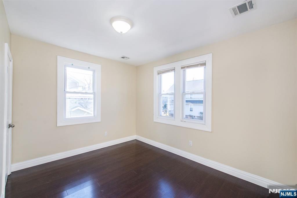 145 Reade Street Englewood, NJ 07631 - Photo 13 of 20 an empty room with wooden floor and windows