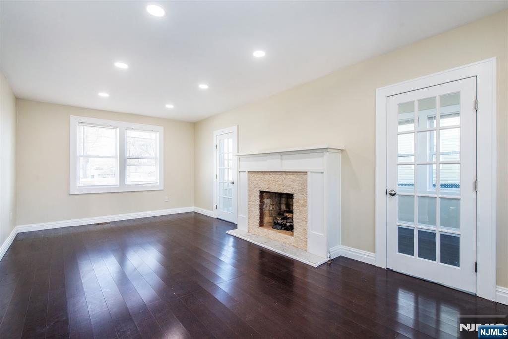 145 Reade Street Englewood, NJ 07631 - Photo 3 of 20 a view of an empty room with wooden floor fireplace and a window