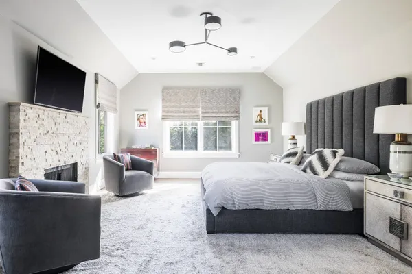 a bedroom with a large bed couch and a flat tv screen