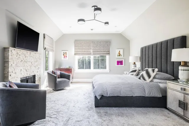 a bedroom with a large bed couch and a flat tv screen