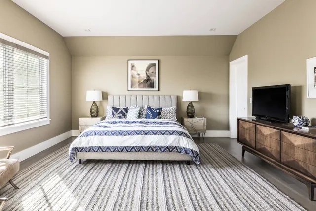 a bedroom with a bed and a flat screen tv