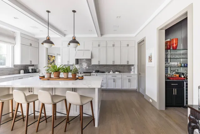 a kitchen with stainless steel appliances kitchen island granite countertop a table and chairs in it