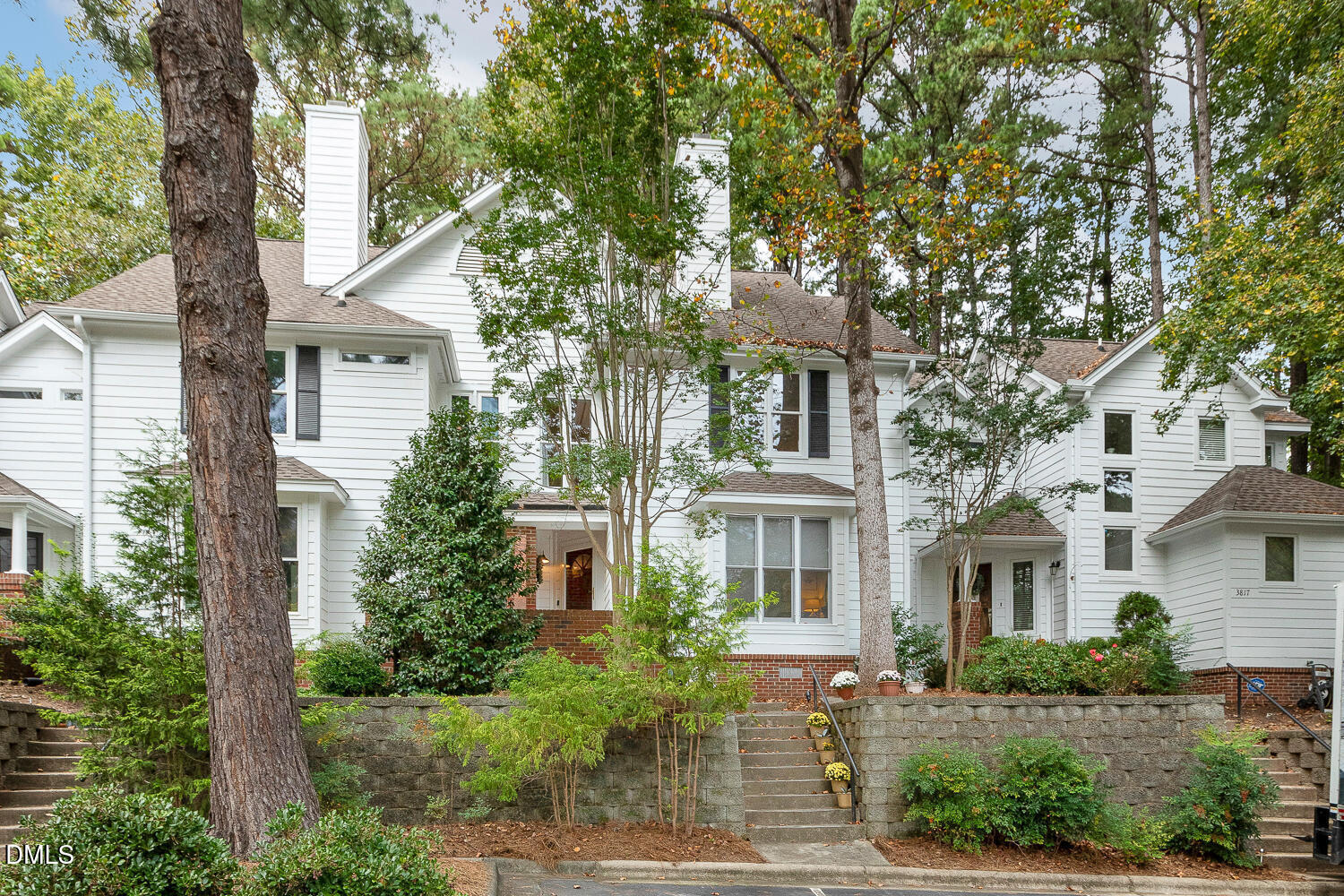 a front view of a house with trees and plants