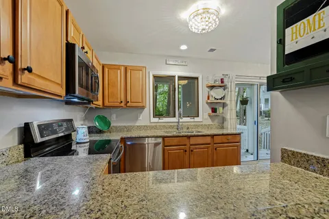 a kitchen with stainless steel appliances granite countertop a sink a stove and a refrigerator
