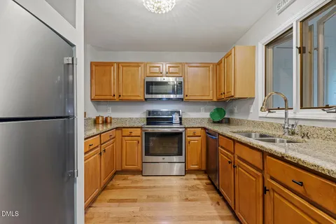 a kitchen with stainless steel appliances granite countertop a stove a sink and a refrigerator