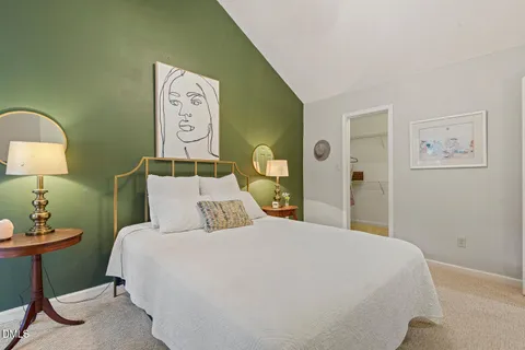a bedroom with a bed and painting on the wall
