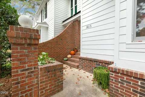 a view of brick house with potted plants