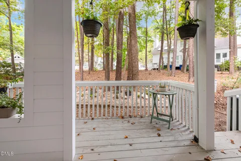 a view of a porch with a table and chairs and potted plants