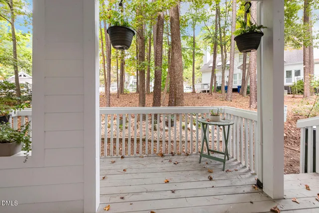 a view of a porch with a table and chairs and potted plants