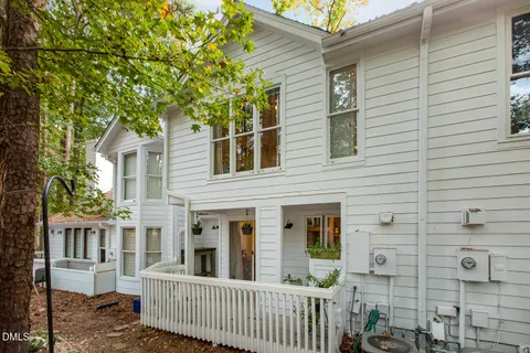 a view of a house with a small yard and wooden fence