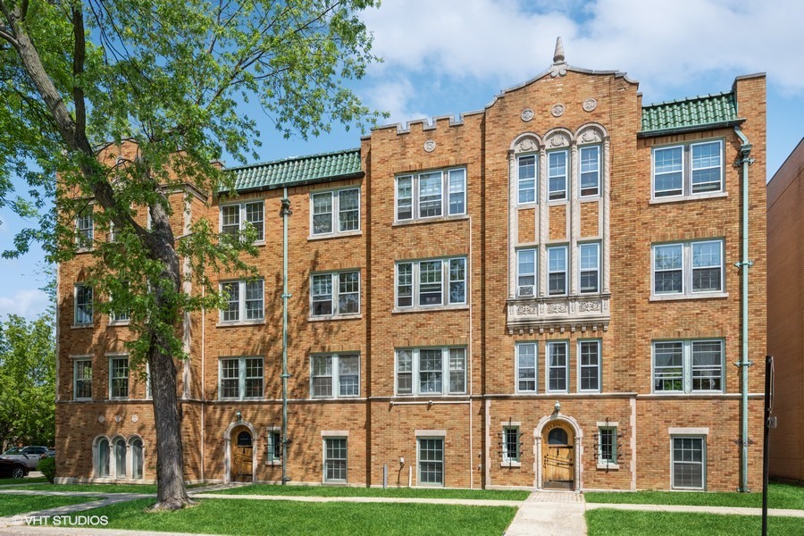 6881 North Overhill Avenue, Unit 1 Chicago, IL 60631 - Photo 1 of 17 a front view of a residential apartment building with a yard