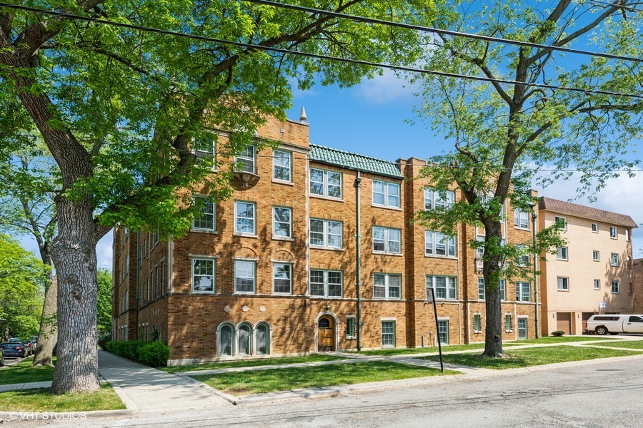 6881 North Overhill Avenue, Unit 1 Chicago, IL 60631 - Photo 13 of 17 a view of a brick building next to a yard