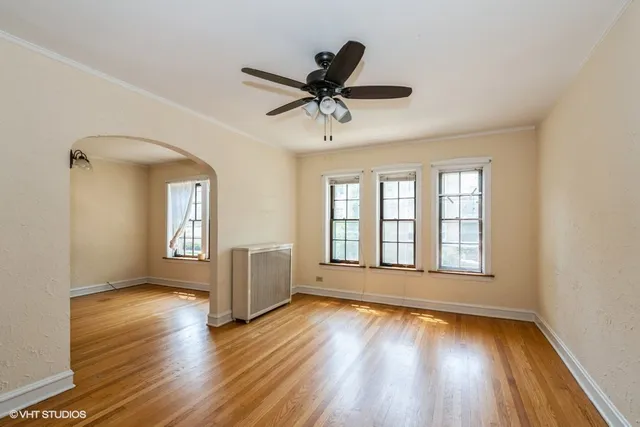 a view of an empty room with window and wooden floor