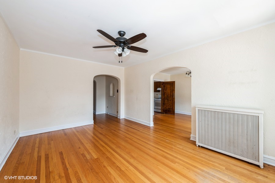 6881 North Overhill Avenue, Unit 1 Chicago, IL 60631 - Photo 3 of 17 a view of empty room with wooden floor and fan