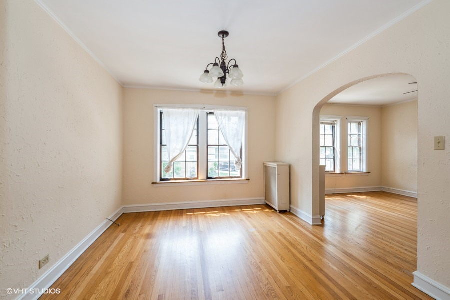 6881 North Overhill Avenue, Unit 1 Chicago, IL 60631 - Photo 5 of 17 a view of an empty room with wooden floor and a window