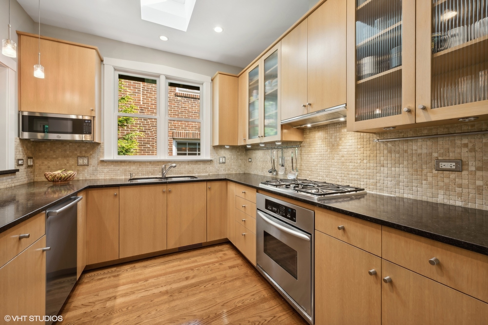 2201 Forestview Road Evanston, IL 60201 - Photo 7 of 27 a kitchen with stainless steel appliances granite countertop a stove a sink and a microwave