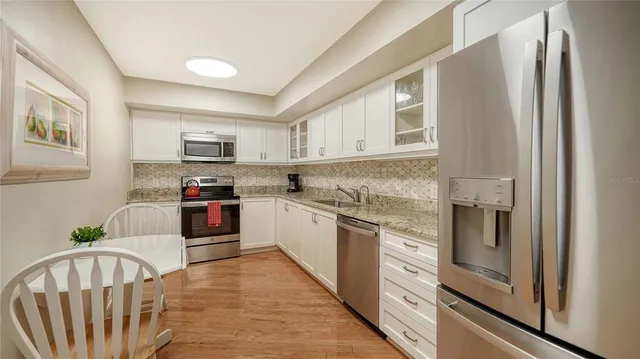 a kitchen with stainless steel appliances granite countertop a refrigerator sink and stove