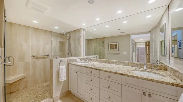 a bathroom with a granite countertop sink mirror and shower