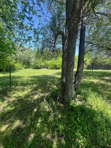 a view of a field with trees in the background