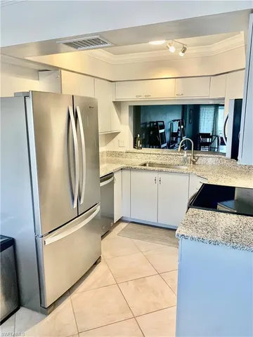 a kitchen with stainless steel appliances granite countertop a refrigerator and a sink