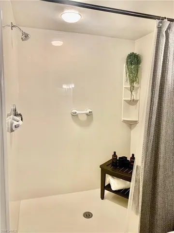 a bathroom with a shower a sink and a mirror