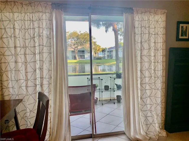 a room with a glass door shower and a chair