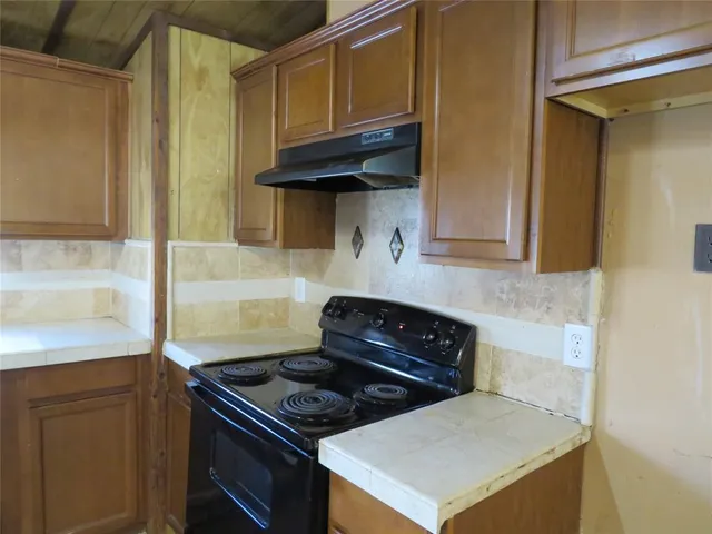 a kitchen with stainless steel appliances granite countertop a stove and a microwave