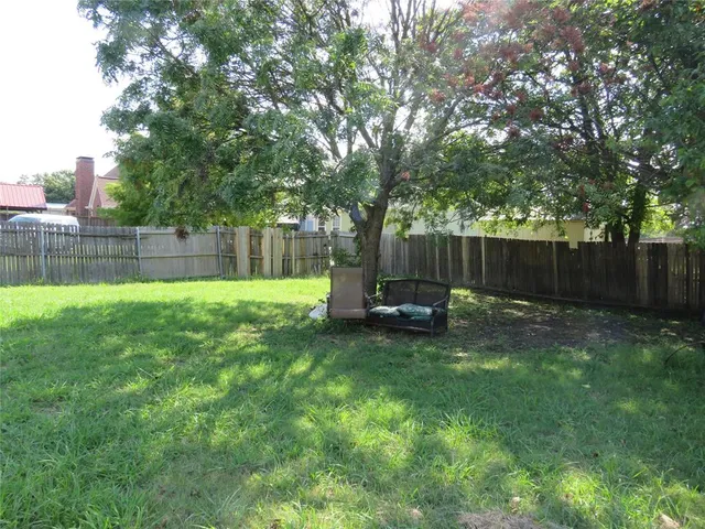 a view of backyard with a barn and large trees