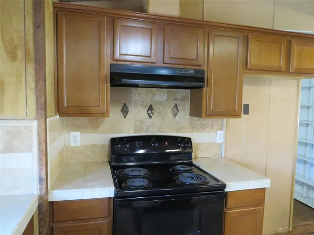 a kitchen with stainless steel appliances wooden cabinets and a stove top oven