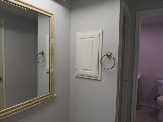 a bathroom with a granite countertop toilet and a mirror