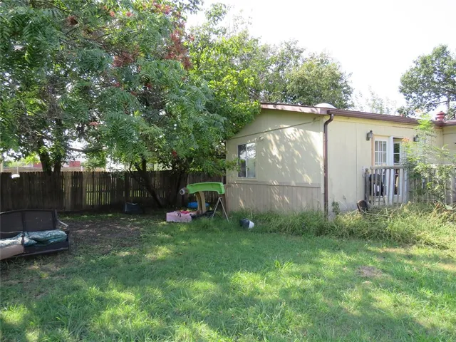 a view of a backyard with a barn and a large tree